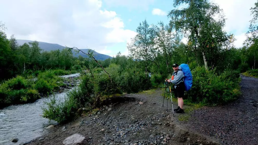 Paul wearing his rain gear next to a stream